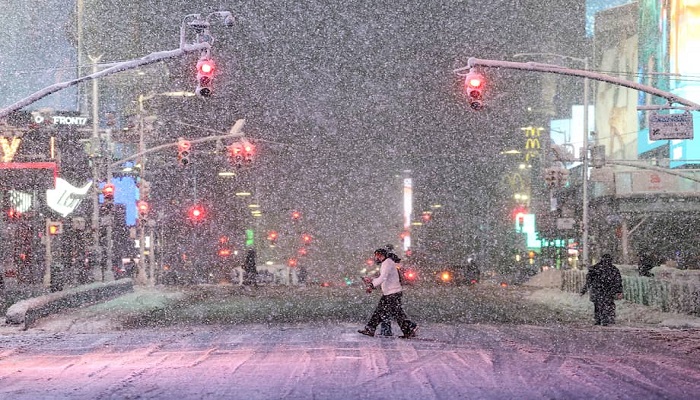 Personas caminan por Times Square, en Manhattan, durante una nevada en Nueva York, el 22 de febrero de 2026. Foto: AFP - CHARLY TRIBALLEAU